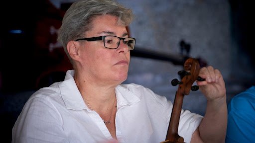 Luthier carefully adjusting a violin